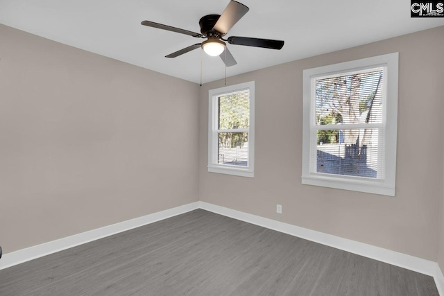 unfurnished room with baseboards, dark wood-style flooring, and ceiling fan