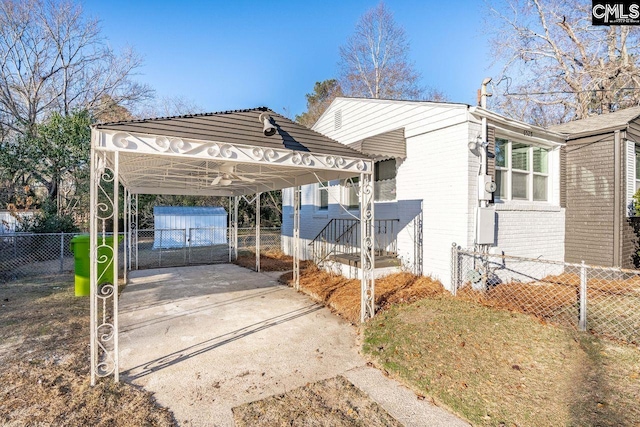 exterior space featuring driveway, a gate, a carport, fence, and brick siding