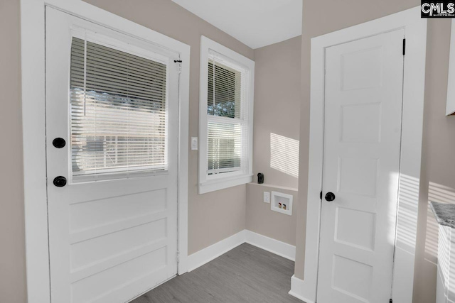 doorway featuring baseboards and wood finished floors