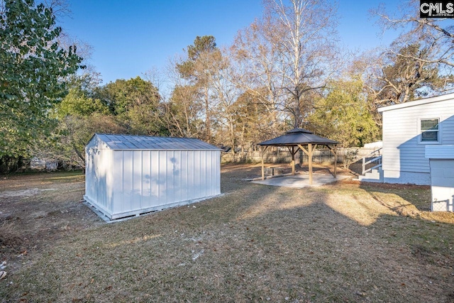 view of yard with a gazebo, a storage unit, and an outbuilding