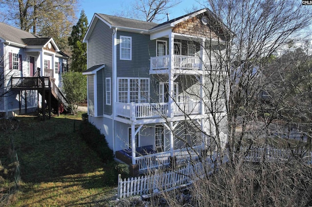 exterior space with stairs, a balcony, and fence