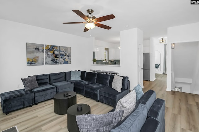 living room featuring light wood-style flooring and ceiling fan