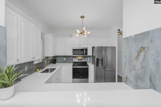 kitchen featuring a sink, tasteful backsplash, appliances with stainless steel finishes, white cabinets, and a chandelier