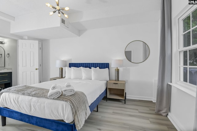 bedroom with visible vents, baseboards, light wood-type flooring, and an inviting chandelier