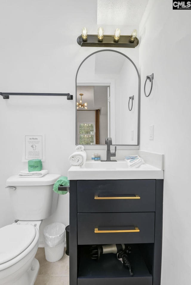 half bathroom featuring vanity, toilet, and tile patterned flooring