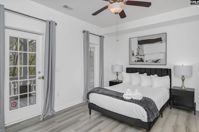 bedroom featuring ceiling fan, wood finished floors, visible vents, and baseboards