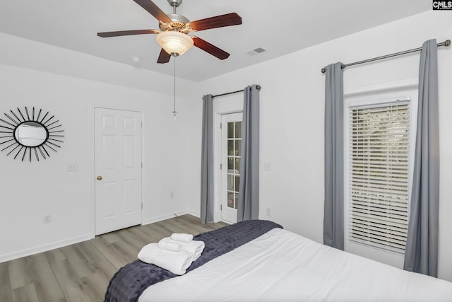 bedroom featuring wood finished floors, visible vents, baseboards, ceiling fan, and access to exterior