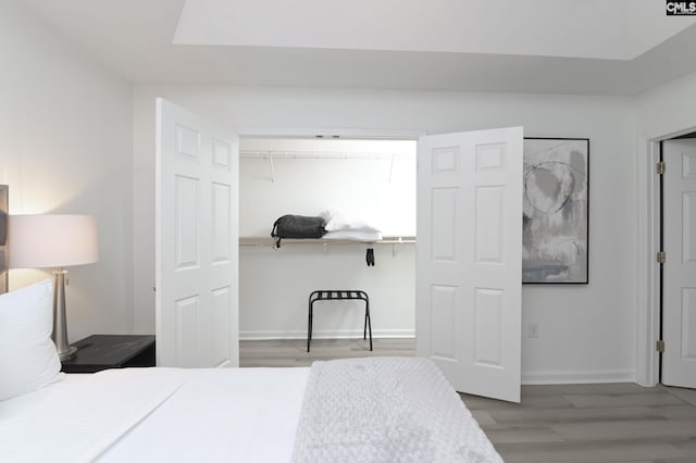 bedroom with a closet, baseboards, and wood finished floors