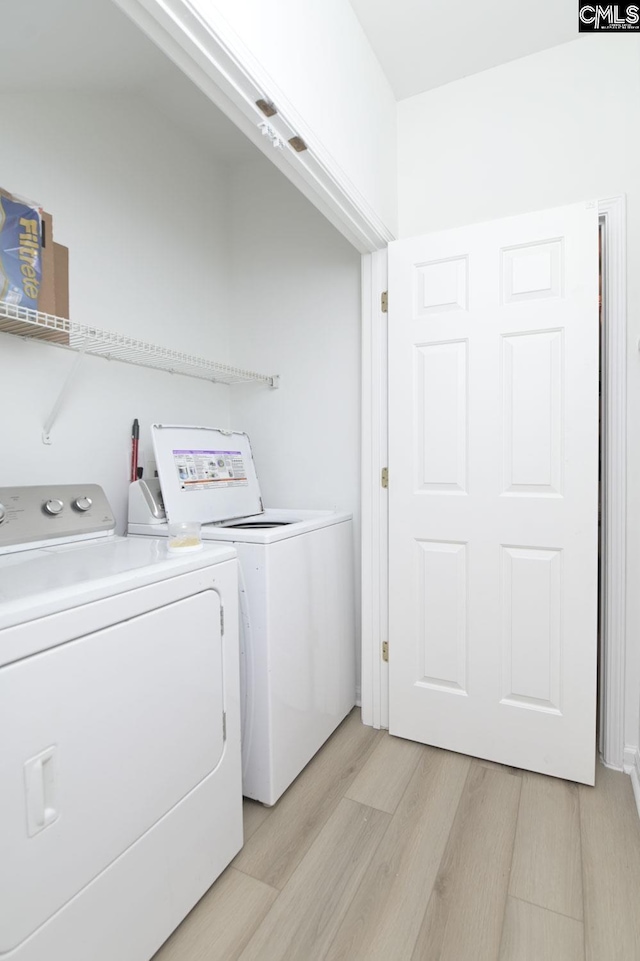 laundry area featuring laundry area, light wood finished floors, and washing machine and clothes dryer