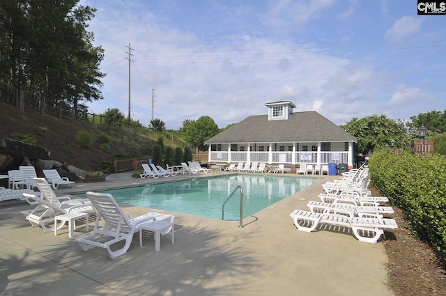 pool with a patio area and fence