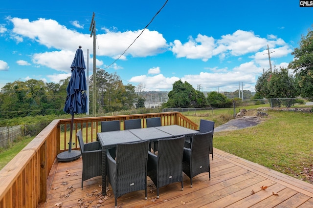 deck with outdoor dining area, a yard, and fence