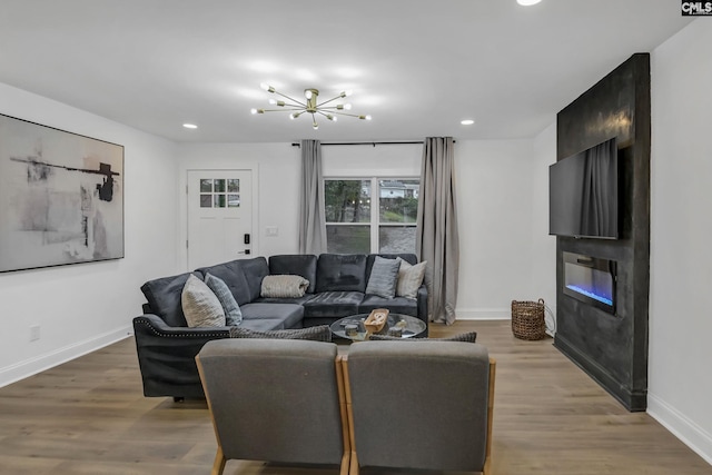 living room featuring baseboards, a large fireplace, and light wood-style floors