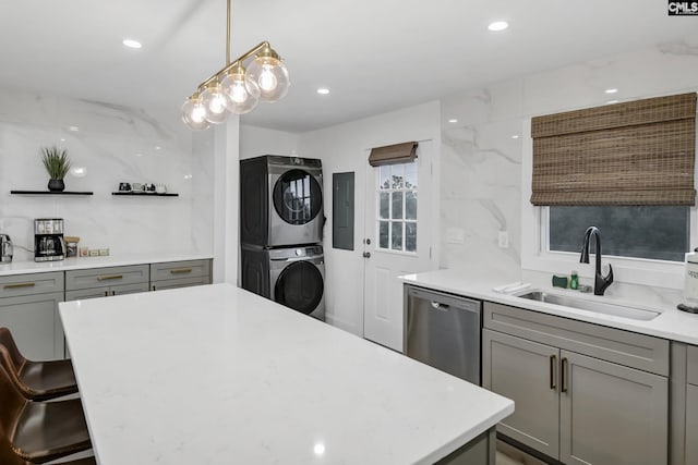 kitchen with stacked washer and dryer, gray cabinetry, a sink, open shelves, and dishwasher