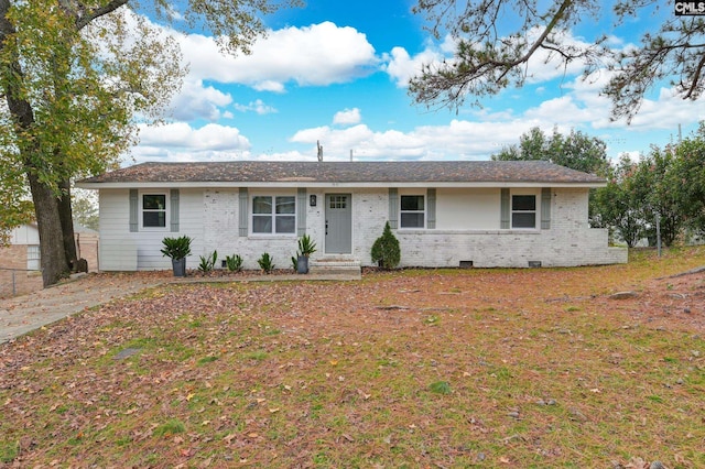 single story home featuring a front yard, brick siding, and crawl space