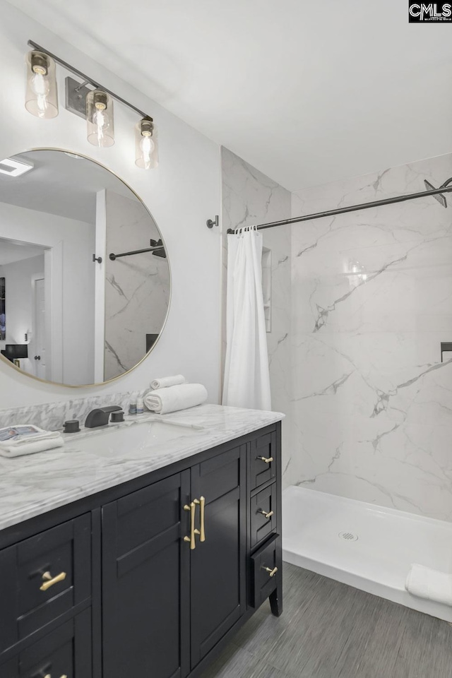 full bathroom with a shower stall and vanity