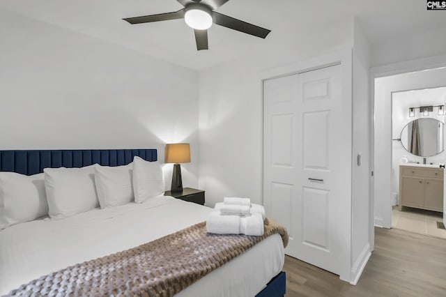 bedroom with ceiling fan, ensuite bath, and wood finished floors