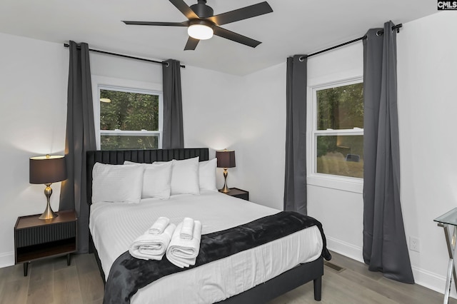 bedroom with wood finished floors, baseboards, and ceiling fan