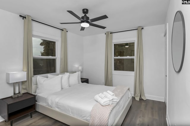 bedroom with baseboards, dark wood-type flooring, and a ceiling fan