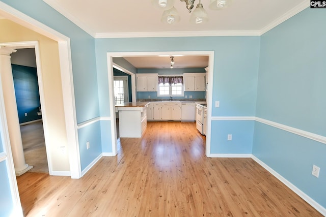 kitchen with white cabinetry, white appliances, light wood-style floors, and baseboards