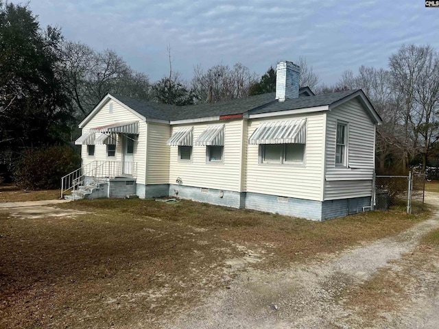 exterior space featuring crawl space and a chimney