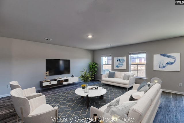 living area with visible vents, wood finished floors, and baseboards