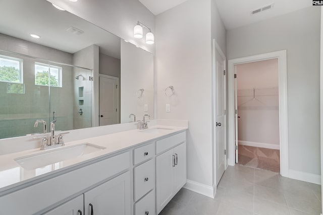 bathroom with a sink, visible vents, a stall shower, and double vanity