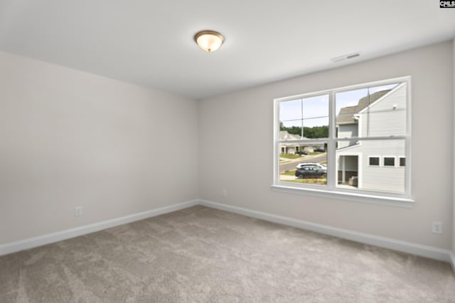 carpeted empty room featuring visible vents and baseboards