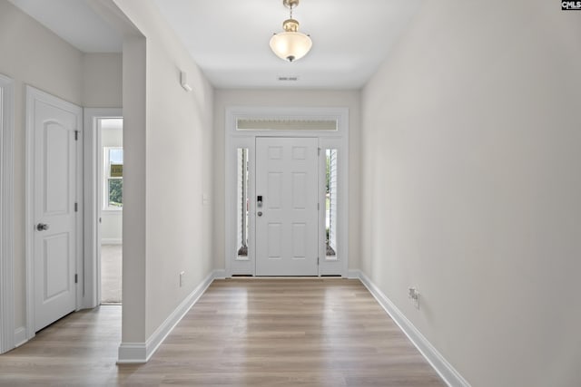 foyer entrance featuring visible vents, light wood-type flooring, and baseboards