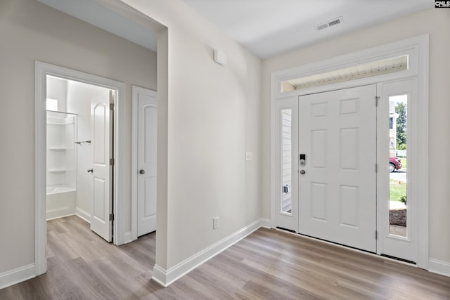 entrance foyer with visible vents, light wood-style flooring, and baseboards