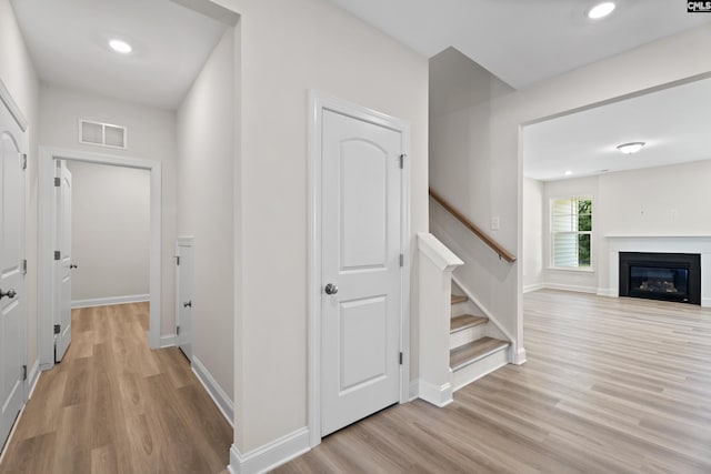 hall with light wood finished floors, visible vents, baseboards, stairway, and recessed lighting