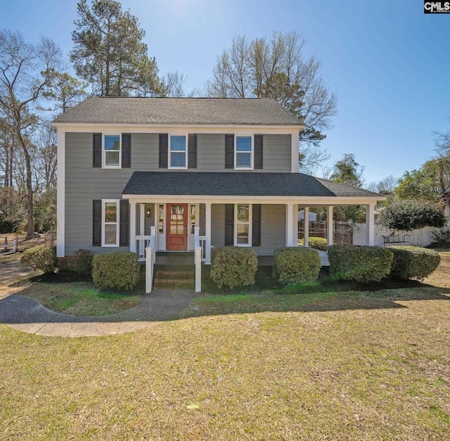 view of front of property featuring covered porch, a front yard, and a shingled roof