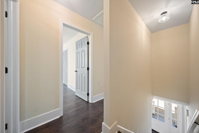 corridor with dark wood-style floors and baseboards