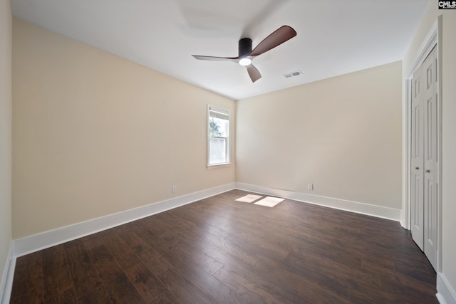 unfurnished bedroom featuring visible vents, dark wood-type flooring, a closet, baseboards, and ceiling fan