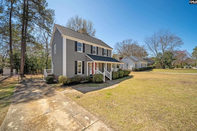 view of front of house featuring a porch, a shingled roof, and a front lawn