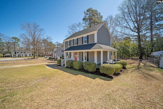 country-style home with covered porch, roof with shingles, a front lawn, and fence