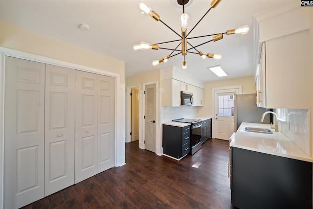 kitchen with a sink, dark wood-style floors, stainless steel appliances, light countertops, and decorative backsplash