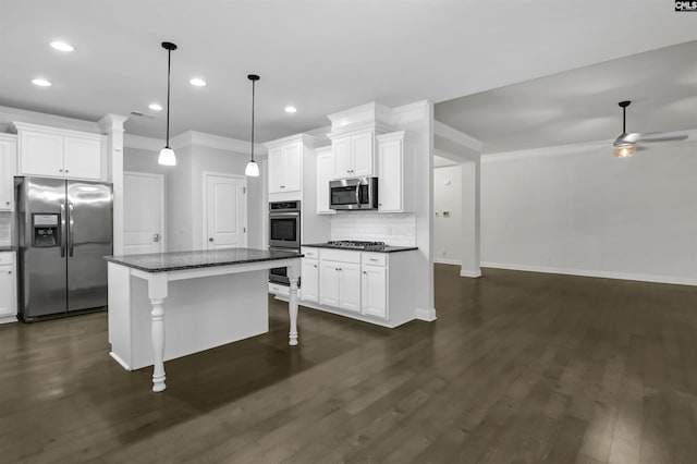 kitchen featuring stainless steel appliances, a breakfast bar area, a ceiling fan, and white cabinets