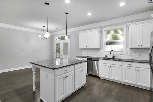 kitchen with dark wood finished floors, ornamental molding, dishwasher, and a sink