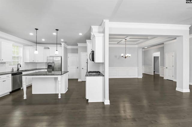 kitchen with stainless steel appliances, white cabinetry, a kitchen breakfast bar, backsplash, and a center island