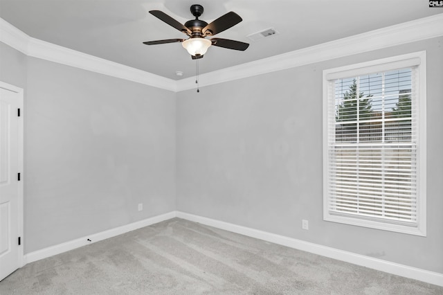 spare room with visible vents, ornamental molding, a ceiling fan, carpet, and baseboards