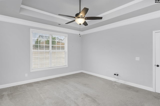 unfurnished room featuring a tray ceiling, carpet flooring, crown molding, and baseboards