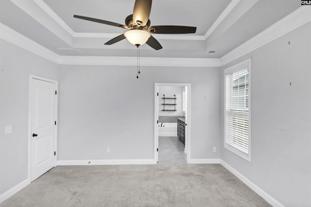 unfurnished room with light colored carpet, baseboards, crown molding, and a tray ceiling