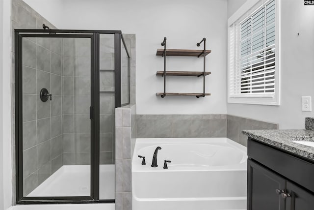 bathroom with a garden tub, a stall shower, and vanity