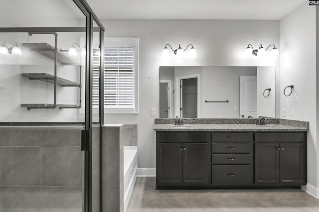 bathroom with a sink, a stall shower, a bath, and double vanity