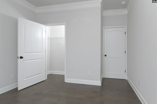 unfurnished bedroom featuring baseboards, dark wood finished floors, and crown molding