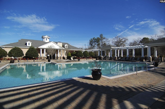 community pool with a patio area and a pergola