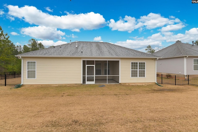 back of property featuring a yard, a shingled roof, a fenced backyard, and a sunroom