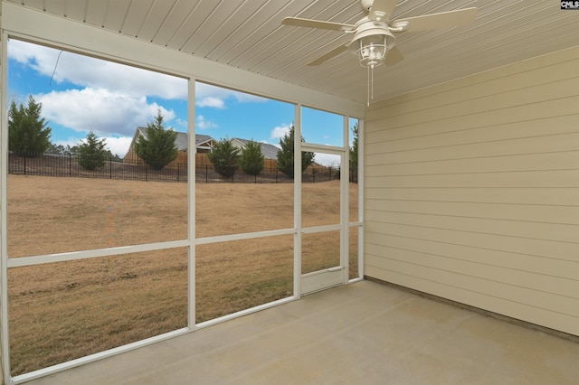 unfurnished sunroom featuring wood ceiling and ceiling fan