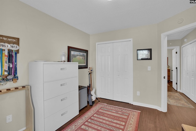 bedroom featuring a closet, baseboards, and wood finished floors