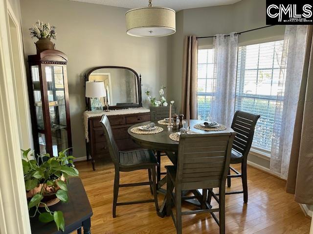 dining space featuring light wood-style flooring and baseboards